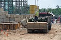Construction workers unloading the sheet pile cofferdam of the lorry at a construction site Royalty Free Stock Photo